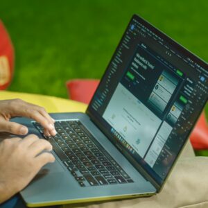 A person using a laptop outdoors on a sunny day, showcasing digital nomad lifestyle.