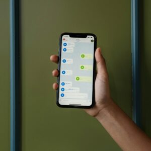 Close-up of a hand holding a smartphone displaying a messaging app.
